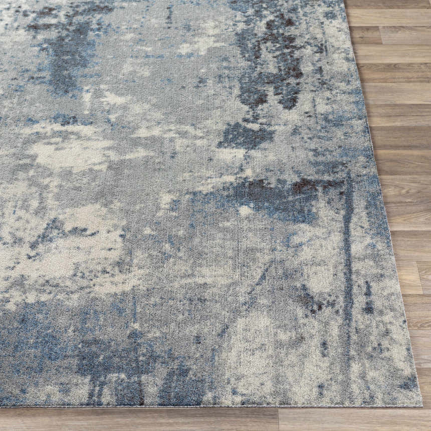 Close-up of Ramsbottom Area Rug. Contemporary design in black, blue, charcoal, and cream on a wood floor. Front