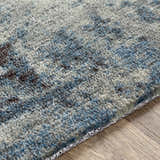 Close-up of the Ramsbottom Area Rug showing its blue, cream, and charcoal contemporary pattern and woven texture. Texture