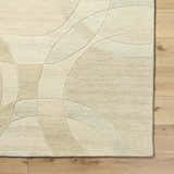 Close-up of the Rollo Area Rug in ash, pearl, and tan. Hand-tufted wool rug with a contemporary geometric pattern. Corner