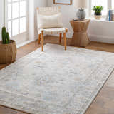 Entryway with Rochedale Area Rug in cream, lavender, and blue. Woven chair, wood table, and cactus add a farmhouse feel. Roomscene-Rectangle