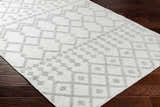 Close-up of the Rick Area Rug showing its geometric pattern and gray and arctic stone colors on dark wood flooring. Corner