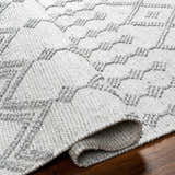Close-up of the hand woven Rick Area Rug in arctic stone and gray, showing geometric farmhouse design and recycled PET yarn texture. Fold