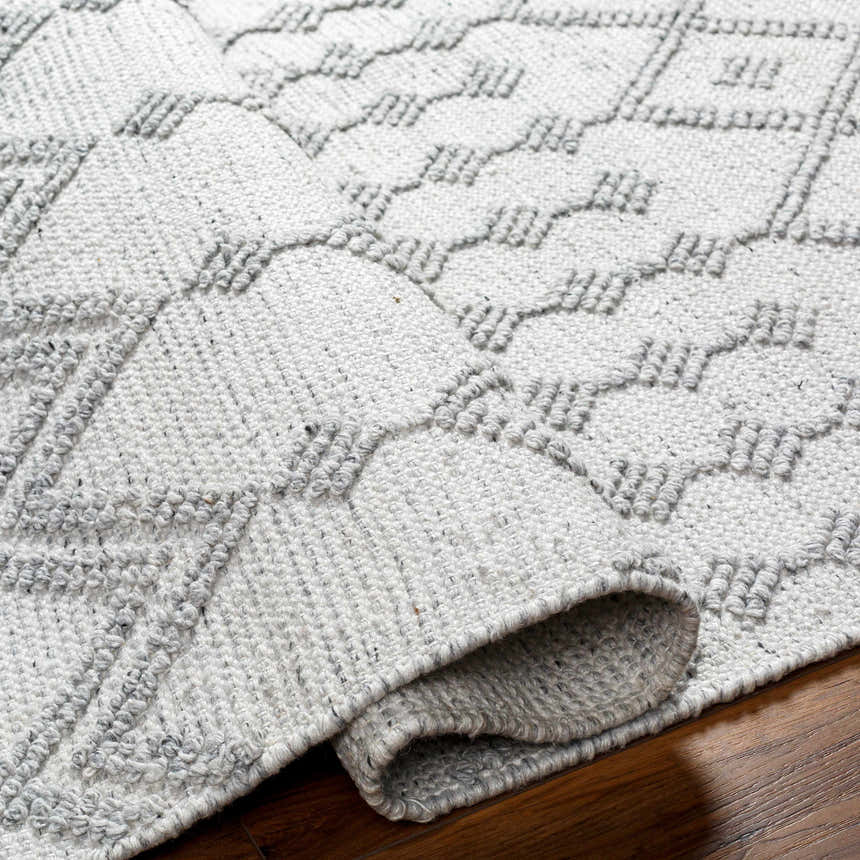 Close-up of the hand woven Rick Area Rug in arctic stone and gray, showing geometric farmhouse design and recycled PET yarn texture. Fold