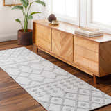 Living room scene with Rick Area Rug runner in arctic stone, gray geometric pattern, wood console table, and potted plant. Roomscene-Runner