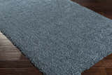 Close up of the teal Rocklake Clearance Rug showing its shag texture on dark wood floors. Corner