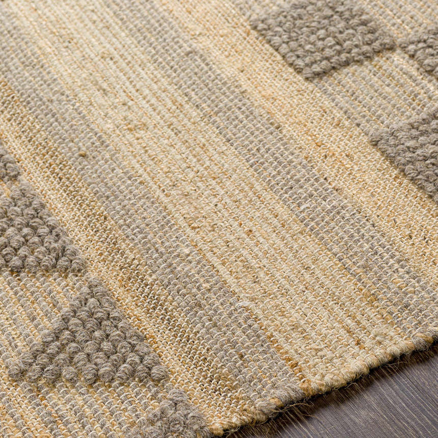 Close-up of the Ardee Totem Rug. Tan jute and gray wool blend with a textured, hand-woven bohemian design. Texture
