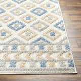 Close-up of the Eivin Pink & Blue Area Rug, a shag rug with diamond and geometric patterns in light blue, gray, and beige. Front