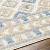 Close-up of the Eivin Pink & Blue Area Rug, a shag rug with a geometric pattern in light blue, gray, and beige. Texture