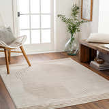 Entryway with Zeke Geometric Nutmeg Rug, white chair, wood bench, and natural light. Calm, inviting home decor. Roomscene-Rectangle