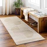 Entryway with Zeke Geometric Nutmeg Rug runner, wood floors, rustic bench, and potted plant near a window. Roomscene-Runner