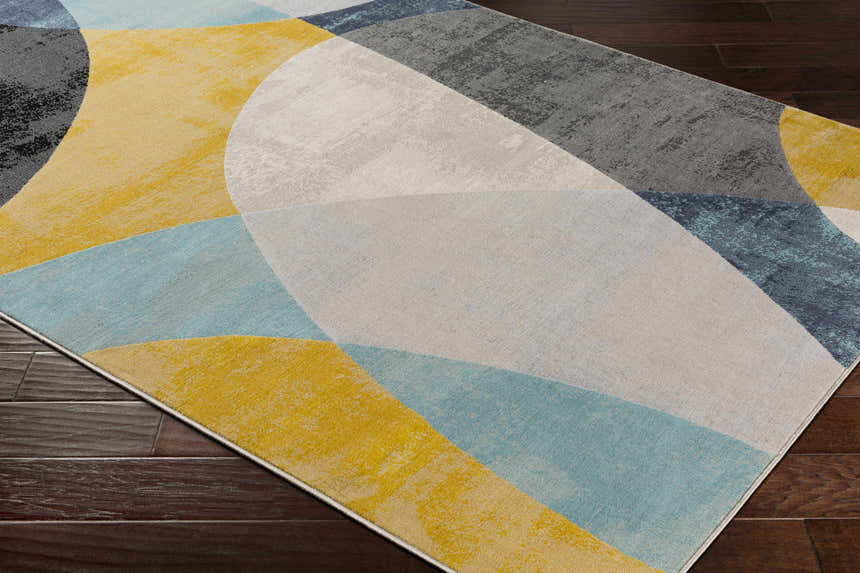 Close-up of Ringgold Area Rug: aqua, charcoal, light slate, mustard, peach, and taupe geometric design. Corner