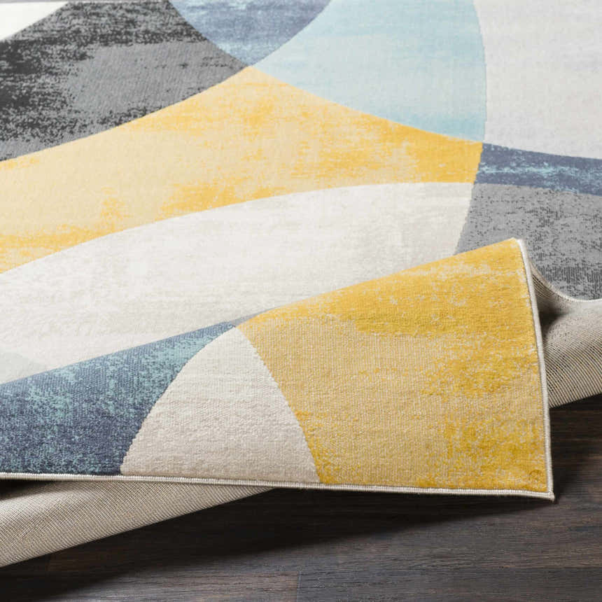Close up of Ringgold Area Rug featuring aqua, charcoal, light slate, mustard, peach, and taupe geometric design. Fold