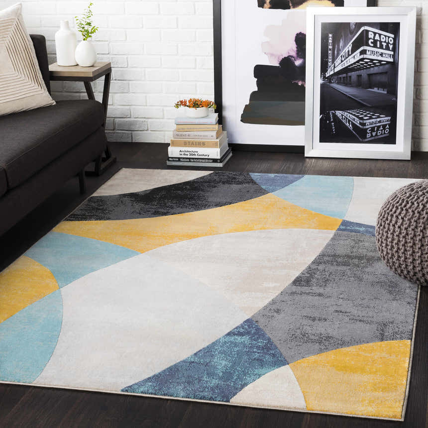 Living room scene with charcoal sofa and Ringgold Area Rug in aqua, charcoal, mustard, peach, and taupe geometric design. Roomscene-Rectangle