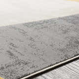 Close-up of Ringgold Area Rug. Abstract design in light slate, taupe, and mustard colors. Clearance rug. Texture
