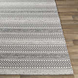 Close-up of Ringtown Washable Area Rug in charcoal and ivory. Bohemian style rug with geometric pattern and machine woven texture. Front