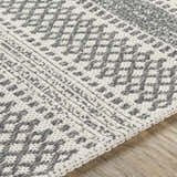Close-up of the Ringtown Washable Area Rug. Charcoal and ivory cotton rug with a woven geometric pattern. Bohemian style. Texture