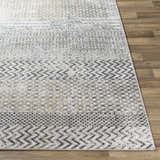 Close-up of Rombauer Area Rug featuring charcoal, gray, and off-white contemporary pattern on a wood floor. Front