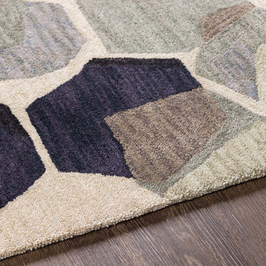 Close up of the hand-tufted Romoland Area Rug. Contemporary geometric design in black, brown, gray, olive, and beige tones. Texture