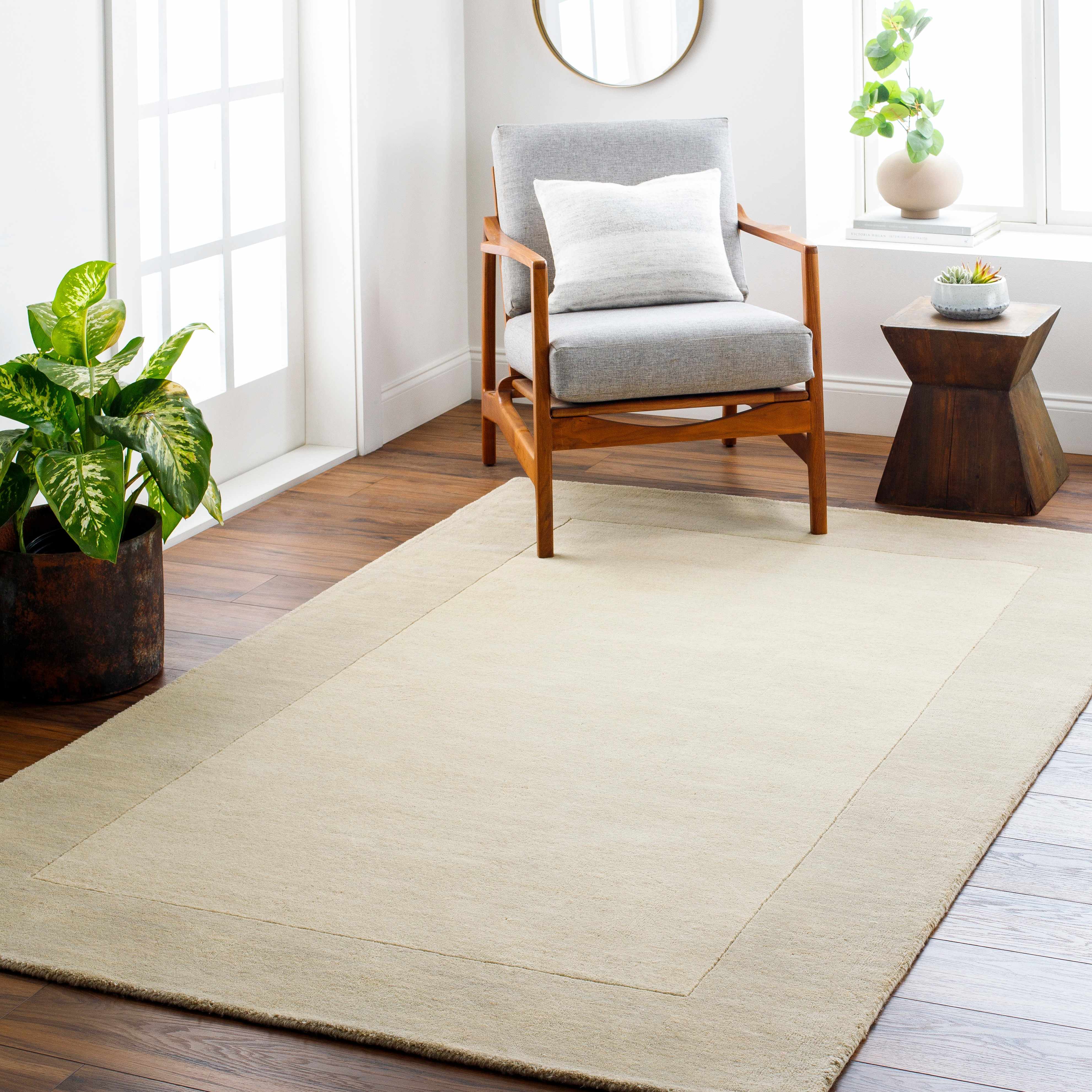 Bordered Solid Beige Cream Wool Rug placed in a styled room setting, harmonizing with surrounding room decor. Contemporary Area Rug Backing Canvas 