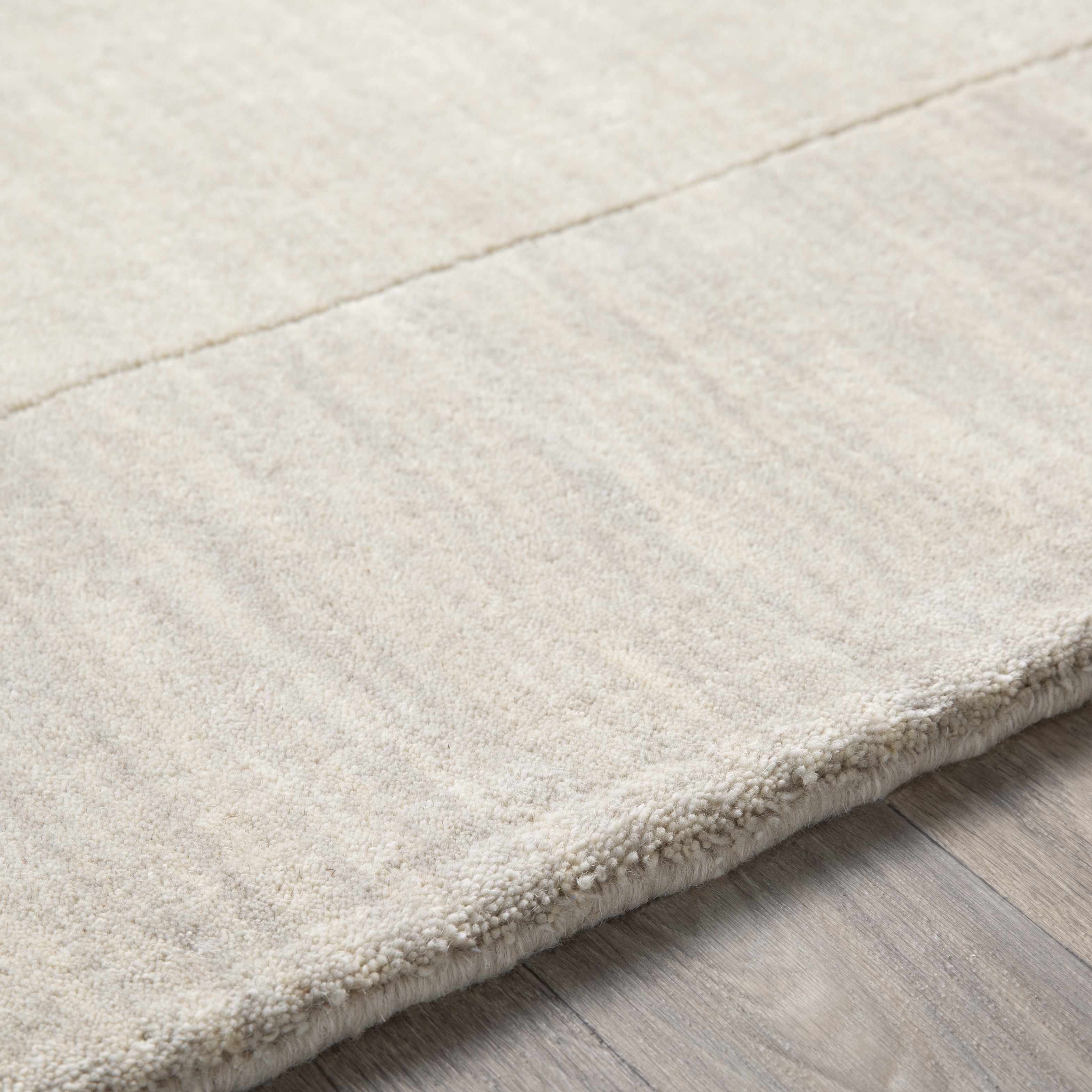 Close-up of the texture on Bordered Solid Beige Cream Wool Rug, showing fabric weave and feel. Contemporary Area Rug Backing Canvas 2' x 3' Rectangle3'3" x 5'3" Rectangle6' x 9' Rectangle7'6" x 9'6" Rectangle9' x 13' Rectangle12' x 15' Rectangle9'9" Square