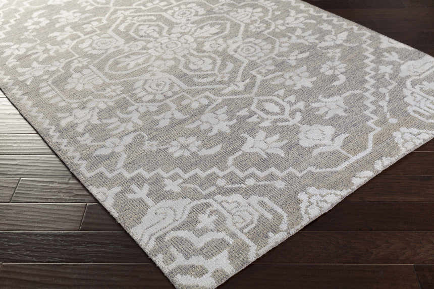 Close-up of the Roxobel Clearance Rug. Light and medium gray farmhouse rug with a traditional, hand-knotted pattern. Corner