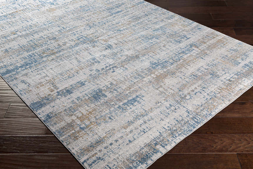 Close-up of Runa Area Rug showcasing its contemporary blue, brown, and off white abstract pattern and soft texture. Corner