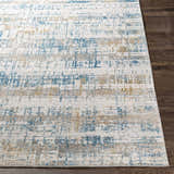 Close-up of the Runa Area Rug showing its blue, mustard, and gray contemporary pattern and soft texture. Front