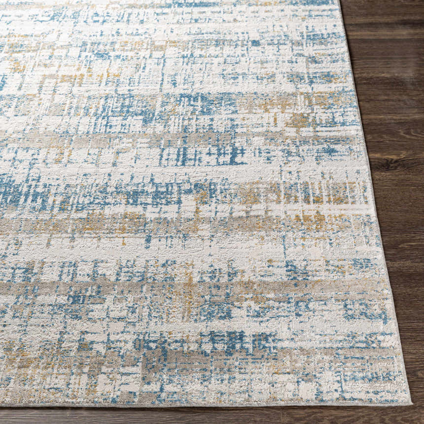 Close-up of the Runa Area Rug showing its blue, mustard, and gray contemporary pattern and soft texture. Front