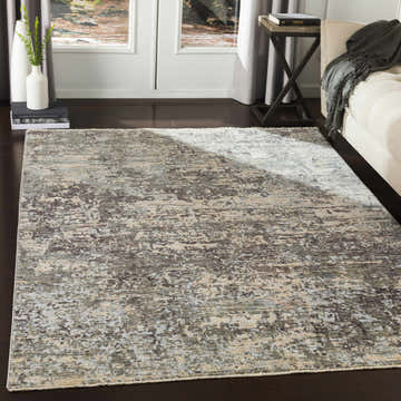 Living room scene with a contemporary Riverhead Carved Statement Rug in blue, charcoal, and gray tones. Neutral sofa and dark wood floors. Roomscene-Rectangle