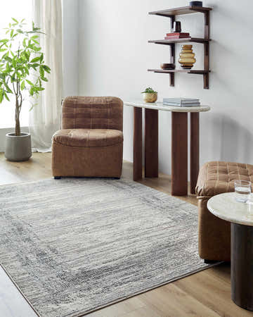 Living room scene with a cream and gray Ranya Area Rug, leather chairs, and wood accents. Roomscene-Rectangle