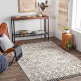 Living room scene with Reyn Area Rug, brown leather chair, and wood console table. Bohemian style. Roomscene-Rectangle