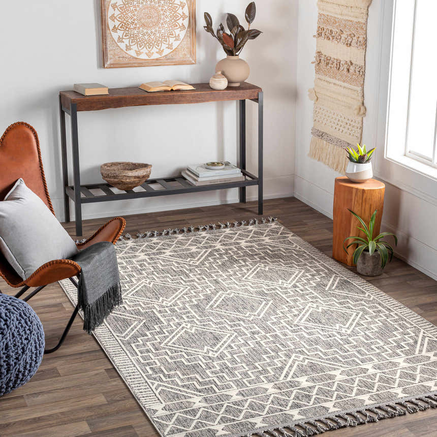 Living room scene with Reyn Area Rug, brown leather chair, and wood console table. Bohemian style. Roomscene-Rectangle
