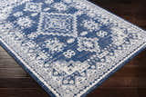 Ryton White&Blue Area Rug: Bohemian style rug with floral and geometric patterns in blue and white on dark wood floor. Corner
