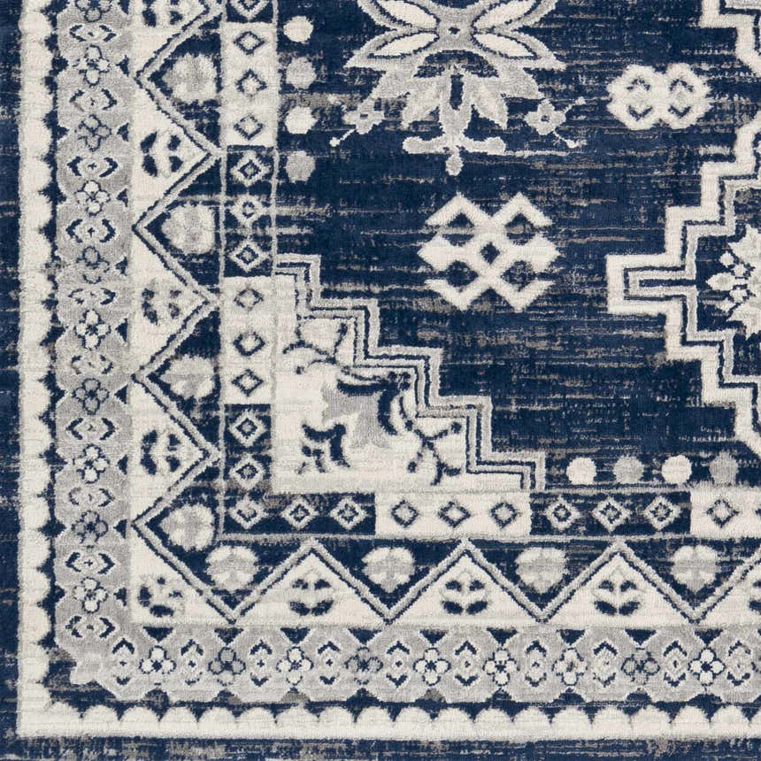 Close up of the Ryton White&Blue Area Rug showcasing its bohemian, geometric, and floral pattern in navy, white, and gray. Swatch