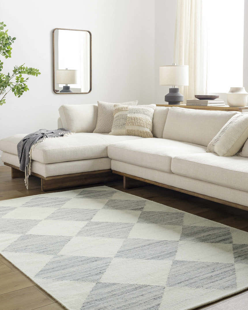 Living room scene with a white sectional sofa and Rakin Pearl Area Rug with a diamond pattern. Roomscene-Rectangle