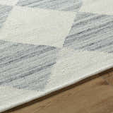 Close-up of the hand woven Rakin Pearl Area Rug. Ivory and silver gray diamond pattern on a farmhouse style cotton and wool rug. Texture