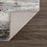 Close-up of the Liverpool Area Rug showing its colorful abstract pattern, soft texture, and durable backing on a wood floor. Fold