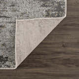 Close-up of the Liveree Abstract Area Rug showing light gray, medium gray, off white, and rust colors and woven backing. Fold