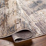 Close-up of the Asuna Area Rug, showcasing its beige, brown, and gray contemporary pattern and soft texture. Fold