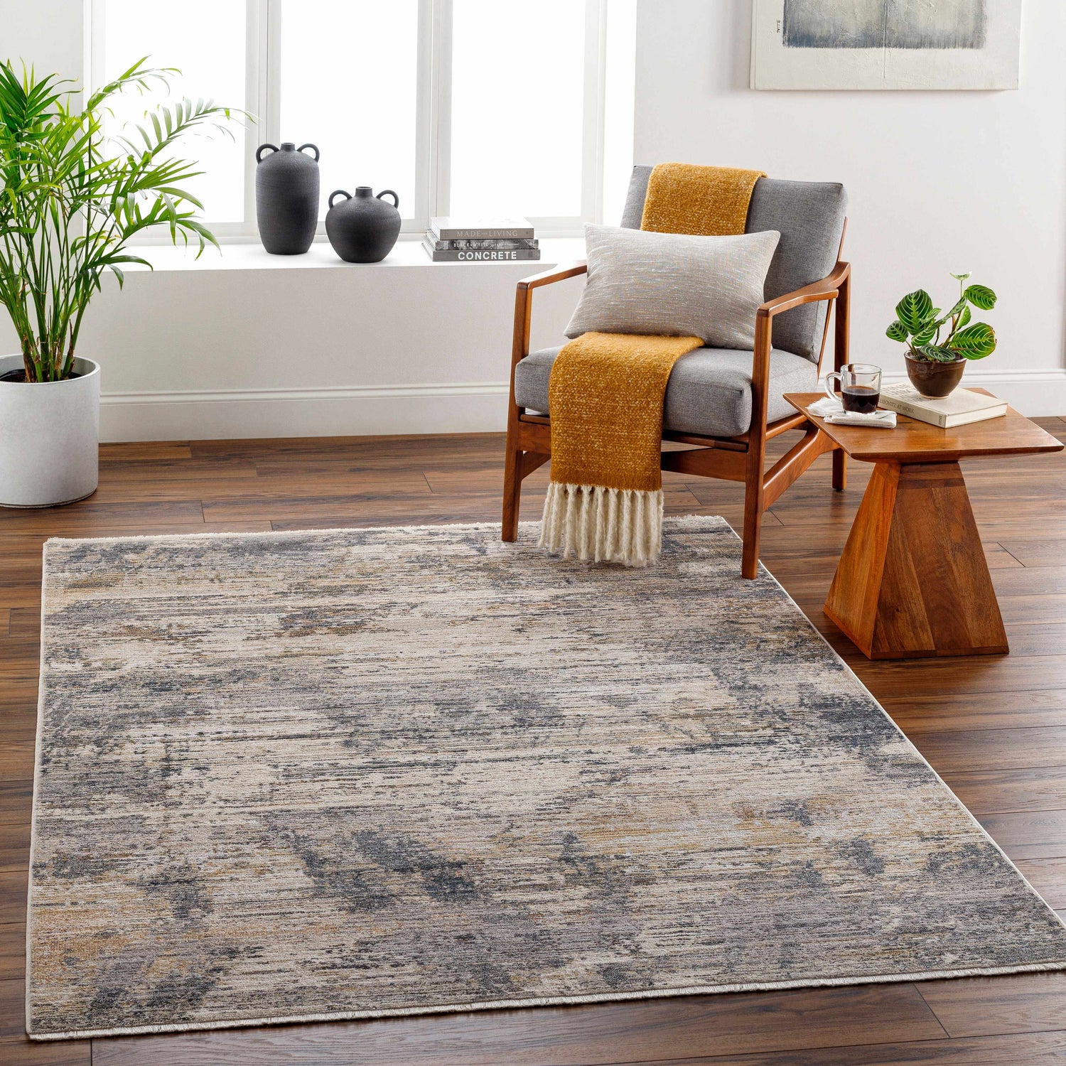 Living room scene with Asuna Area Rug in beige, gray, and brown. Contemporary rug styled with wood chair, side table, and plants. Roomscene-Rectangle