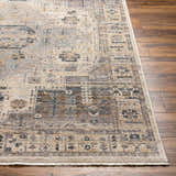 Close-up of the Iiona Area Rug, a traditional rug with a multi-brown, gray, and taupe pattern on a wood floor. Front
