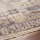 Close-up of the Iiona Area Rug. Farmhouse style rug with brown, gray, and taupe tones and a traditional pattern. Texture