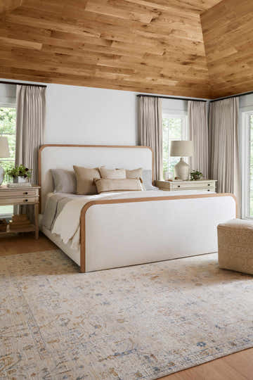Bedroom scene with a beige and blue Sackville Premium Area Rug under a bed. Roomscene-Rectangle