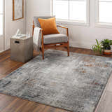 Living room scene with Ervin Gray Area Rug, gray chair with orange pillow, and modern decor. Roomscene-Rectangle