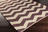 Close-up of the Saginaw Jute Carpet showing a beige and dark purple zig-zag pattern and hand woven texture. Corner