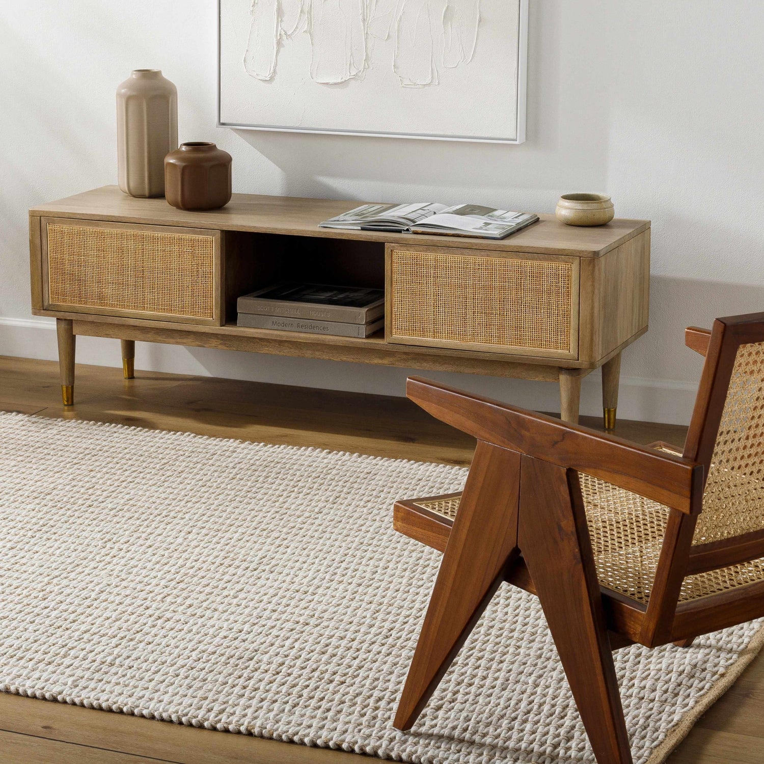 Living room scene with beige Ieuan Area Rug, wood console table with vases, and mid-century modern chair. Roomscene-Rectangle
