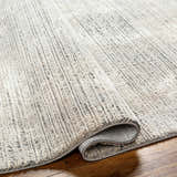 Close-up of the Chiyo Tan Plush Textured Washable Rug showing the plush texture and tan and gray color variations. Fold