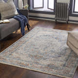Living room scene with a brick red, cream, and navy Salmo Area Rug, gray sofa, and dark wood floors. Roomscene-Rectangle