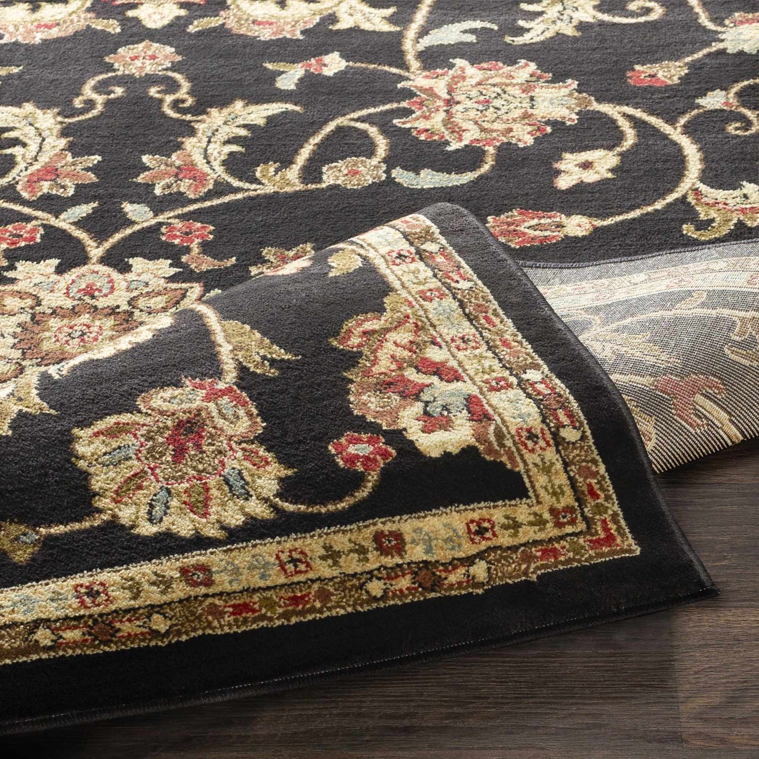 Close-up of the Salona Luxe Black Rug showing its floral pattern, beige border, and soft, textured pile. Fold