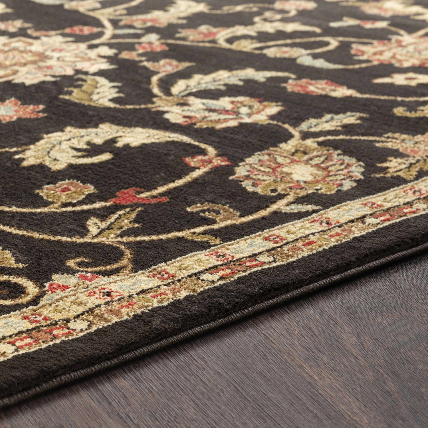 Close-up of the Salona Luxe Black Rug showing its floral pattern in coral, beige, and olive on a dark brown background. Texture